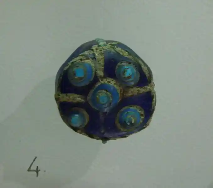 Circular glass buckle with a cross design in the center